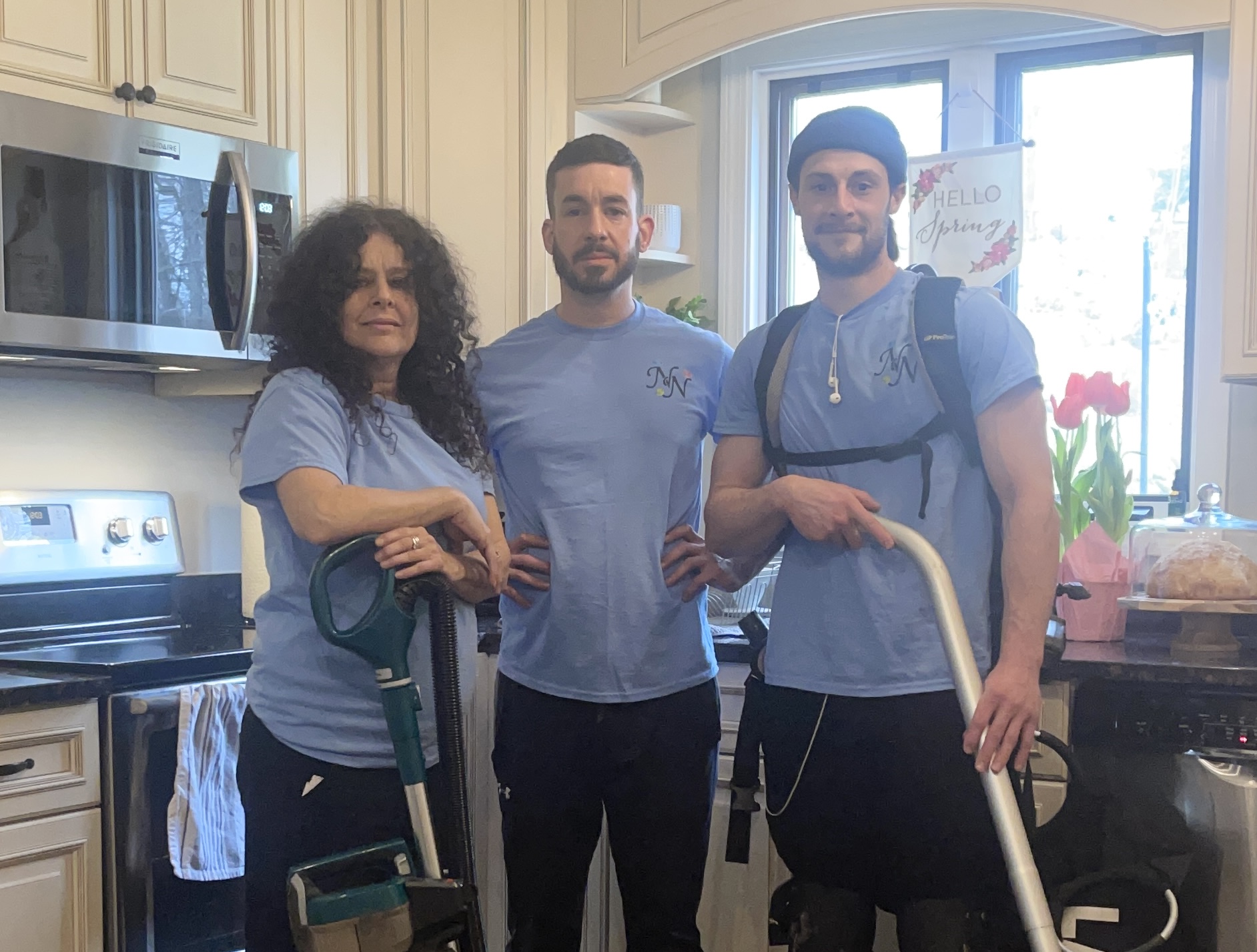 Two company owners and an employee wearing company uniform in a client's home after cleaning.